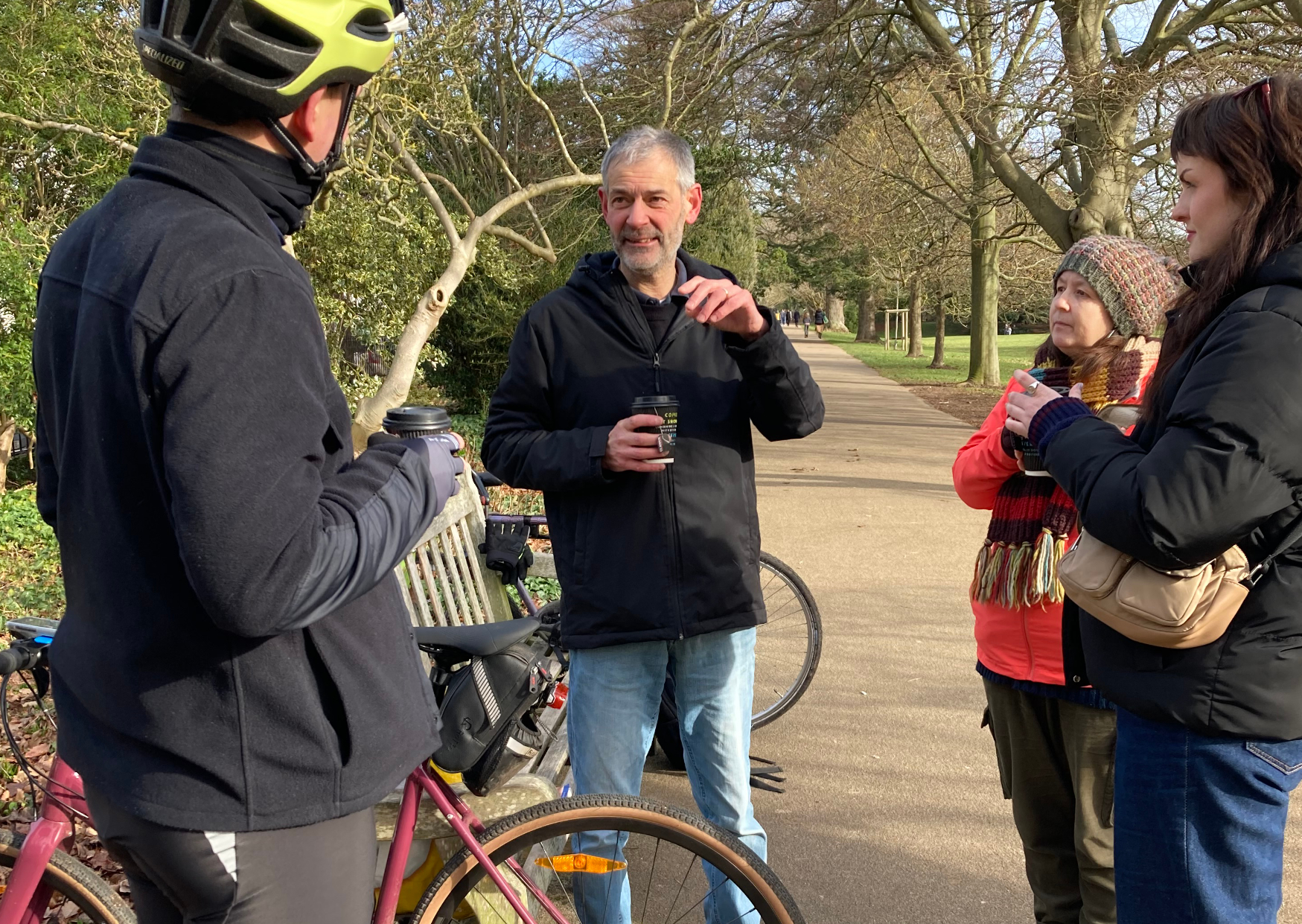 A group of people chat in a park after a bike ride